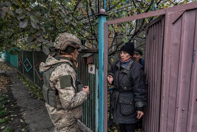 Pipa Vasyl, a policeman of the 'White Angels', tries to convince a local woman to evacuate from Kurakhove, Donetsk region, Ukraine