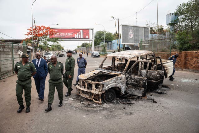 Border officials inspect a burnt-out Mozambican border patrol vehicle