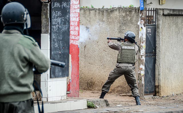 A police officer aims his weapon