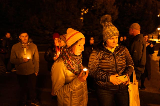 A candlelit vigil, with sombre faces