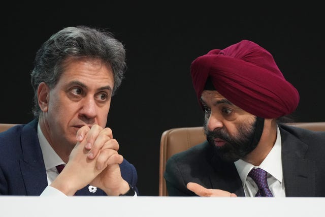 Headshots of Ajay Banga and Ed Miliband talking