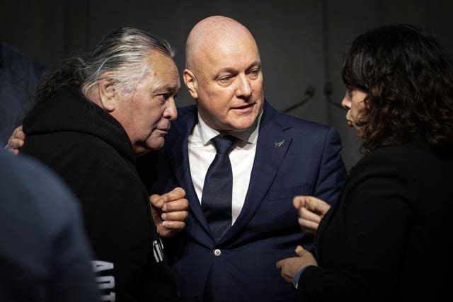 New Zealand’s Prime Minister Christopher Luxon talks to survivor Whiti Ronaki, left, and Laura Cherrington 