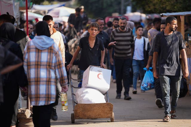 A Palestinian child carries humanitarian aid in Deir al-Balah