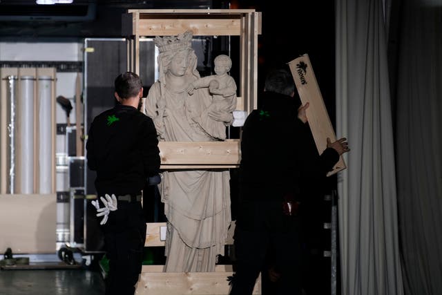 The original Virgin Mary statue, which did not suffer from the 2019 fire, is displayed before returning in the Notre-Dame cathedral outside the cathedral in Paris