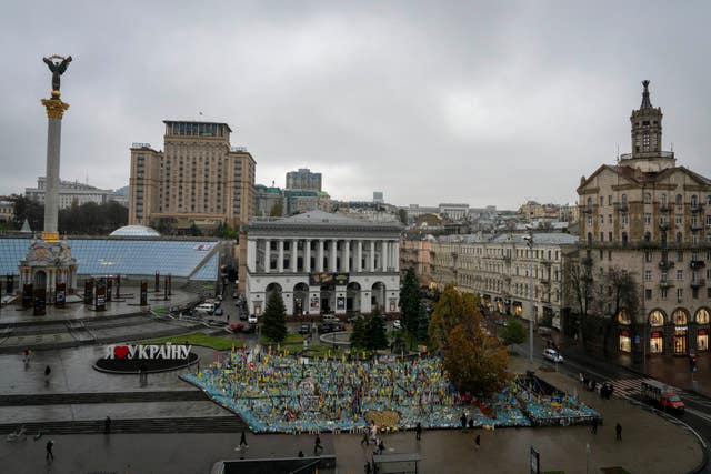 People walk past the memorial to fallen soldiers in Independence Square in Kyiv, Ukraine