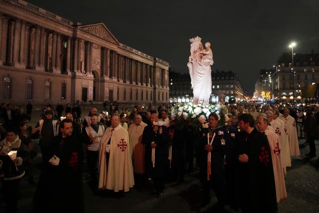 A replica of the Virgin Mary statue is carried from Saint-Germain l’Auxerrois church to Notre-Dame cathedral during a procession in Paris