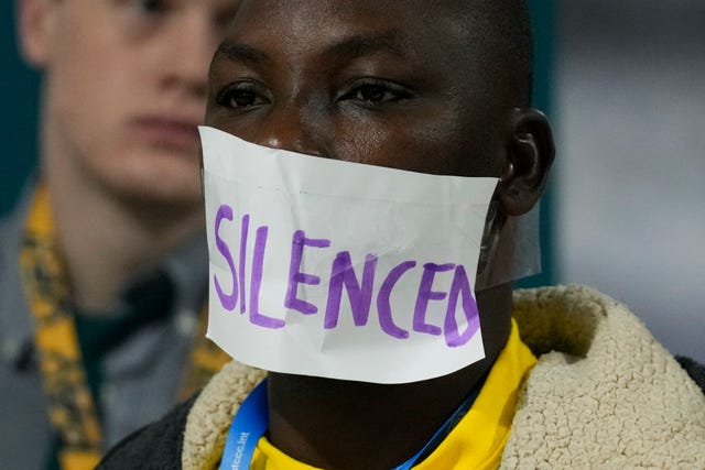 An activist with the word 'silenced' over his mouth