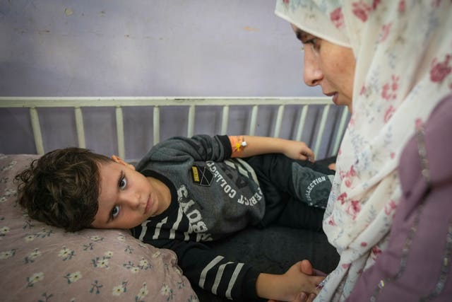 Nima al-Askari, right, cares for her 4-year-old son, Qusay al-Askari, in Deir al-Ballah, Gaza Strip