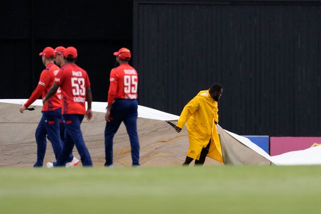 Ground staff bring the covers on to the field as England's players walk off 