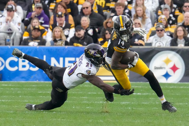 Pittsburgh Steelers wide receiver George Pickens runs with the ball as Baltimore Ravens cornerback Brandon Stephens tries to stop him