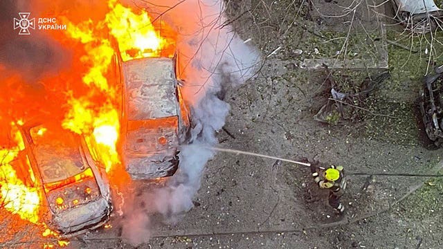 Emergency services personnel work to extinguish a blaze following a Russian rocket attack in Ukraine