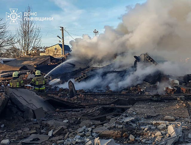 Crews work to extinguish a fire following a Russian rocket attack in Lviv, Ukraine