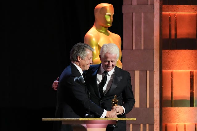 Hugh Grant, left, presents Richard Curtis with the Jean Hersholt Humanitarian Award during the 15th Governors Awards at The Ray Dolby Ballroom in Los Angeles