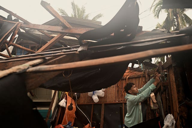 A resident checks belongings from his damaged home in the municipality of Baler, Aurora province, northeastern Philippines 