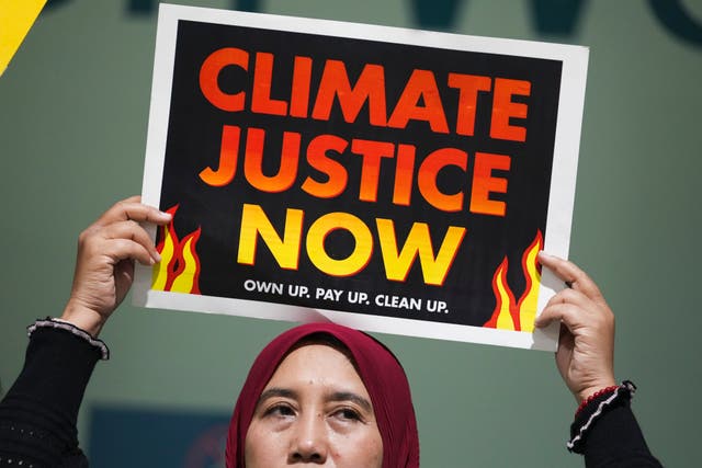 A demonstrator holds a sign that reads 'climate justice now'