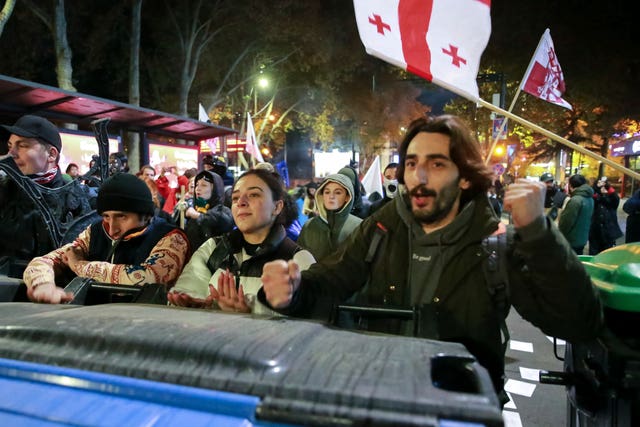 Protesters standing behind a barricade during a rally in Tbilisi 