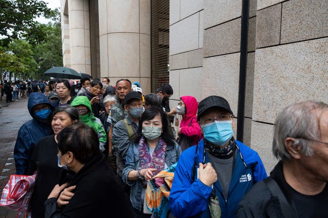 People wait outside the court in Hong Kong ahead of the sentencing 