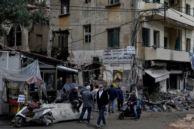 People stand next to a destroyed building hit by an Israeli airstrike in central Beirut 