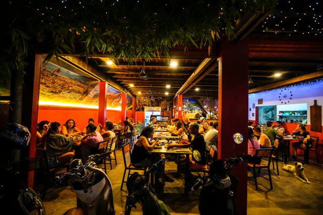 Foreign tourists have a drink at a night club at Nana Backpack hostel in Vang Vieng, Laos