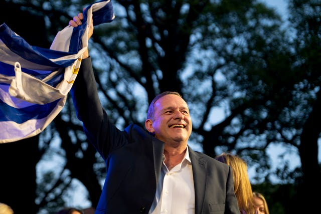 Alvaro Delgado smiling while waving the national flag