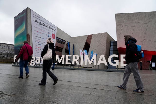 People walking in front of the venue of the 32nd Camerimage International Film Festival in Torun, Poland