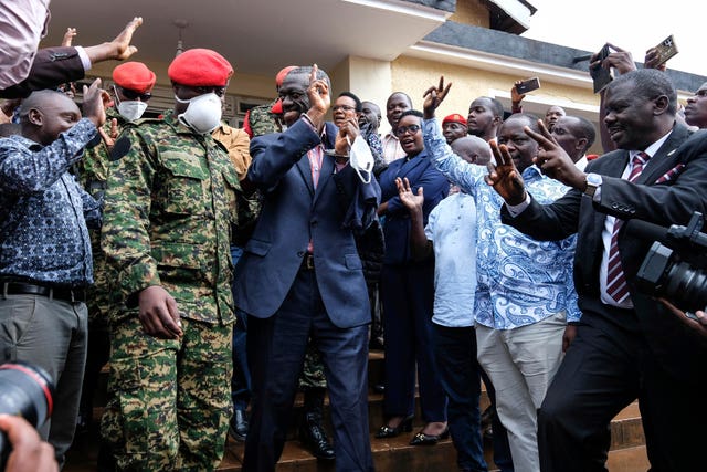 The suspect gestures as part of a large crowd