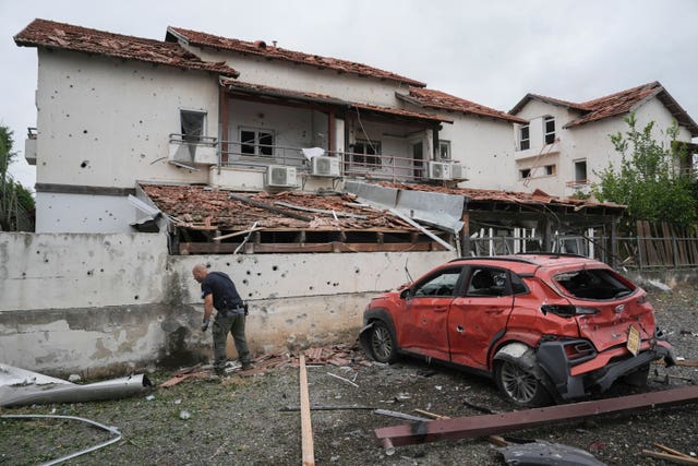 Man examines missile damage at house