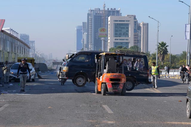 Traffic police officers remove a damaged vehicle in Islamabad