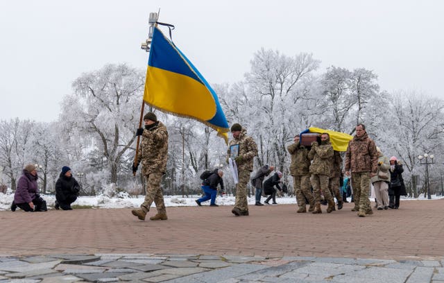 Fellow Ukrainian soldiers carry the coffin of a man who was killed in a battle with Russian troops