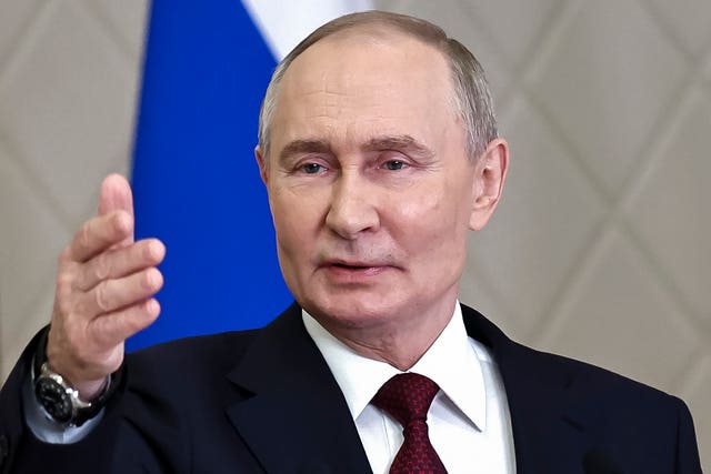 Russian President Vladimir Putin gestures while speaking to the media