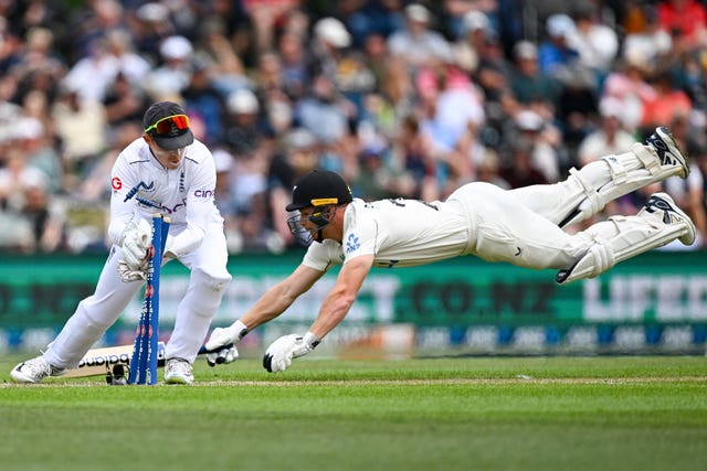 Glenn Phillips of New Zealand dives as England wicketkeeper Ollie Pope knocks off the bails