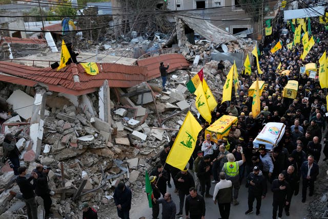 Mourners carry the coffins of Hezbollah fighters killed in the fighting against Israeli troops