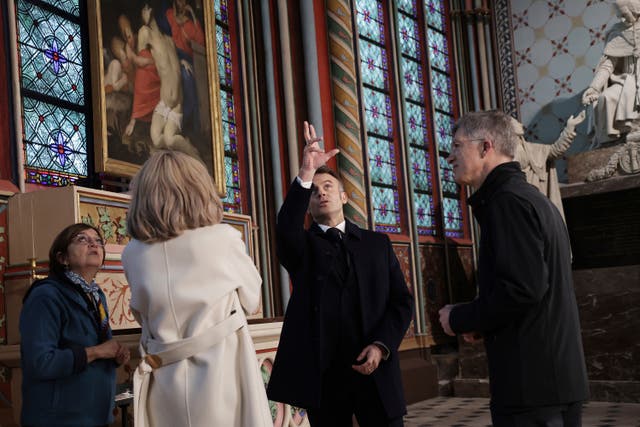 French President Emmanuel Macron looks around the cathedral 