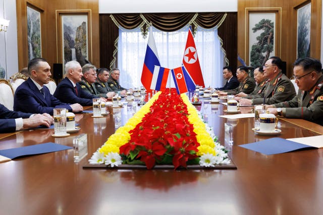 Russia's Andrei Belousov speaks across a table to North Korean defence minister No Kwang Chol