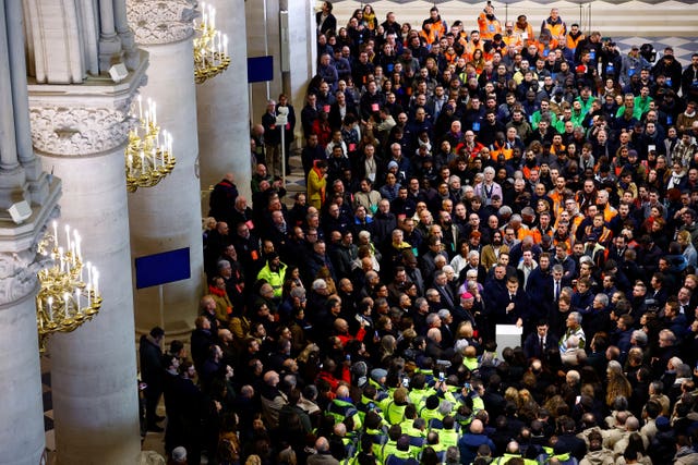 Crowds of construction workers inside the restored Notre Dame cathedral