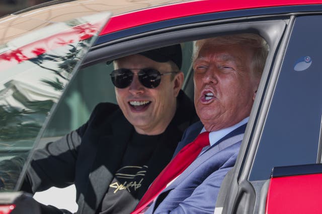 Donald Trump and Elon Musk speak to reporters as they sit in a red Model S Tesla vehicle on the south lawn of the White House