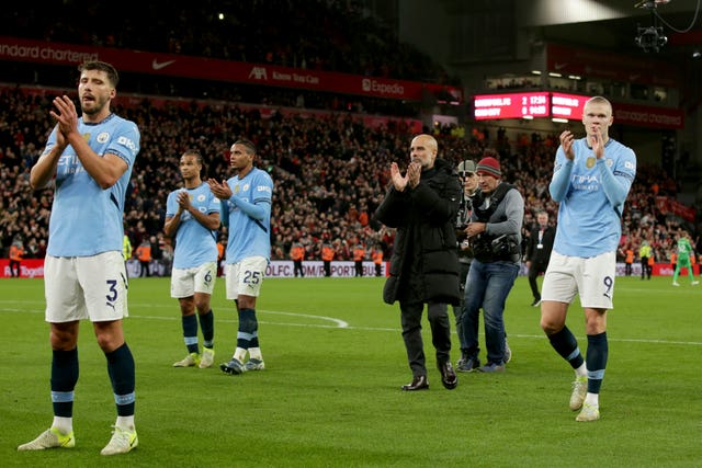 Pep Guardiola and his Manchester City players applaud their fans after defeat at Liverpool