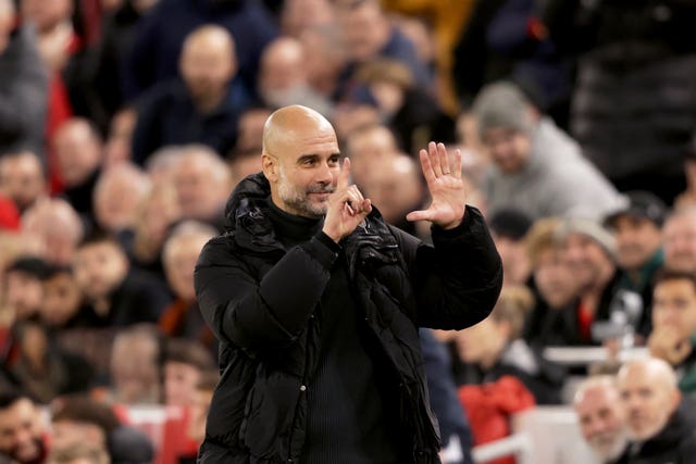 Pep Guardiola holds up six fingers, one for each Premier League title he has won, as he responds to the Liverpool fans at Anfield