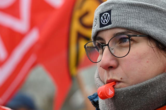 A Volkswagen worker blows a whistle