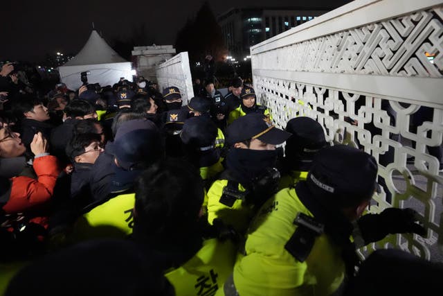 People try to enter as police officers stand guard in front of the National Assembly in Seoul, South Korea 