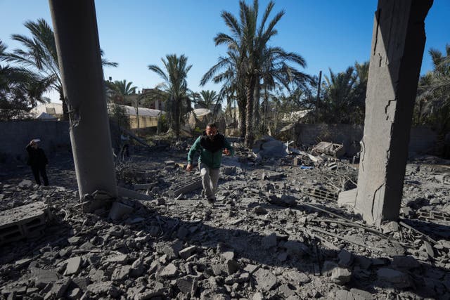 A Palestinian inspects the rubble of a destroyed building