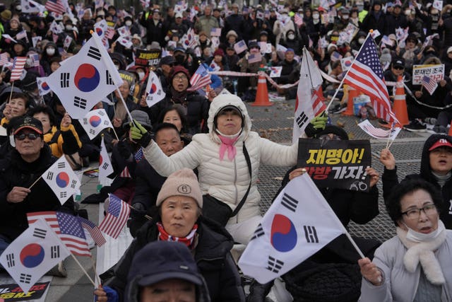 Large crowd waving South Korean and American flags