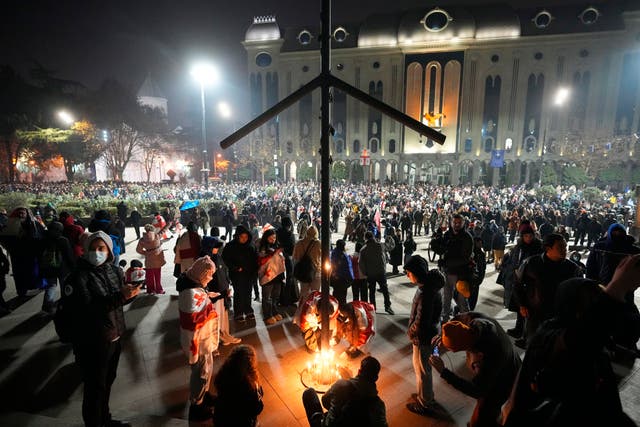 Demonstrators light candles during a rally 