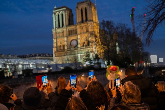 Notre Dame at night, with a crowd gathered outside