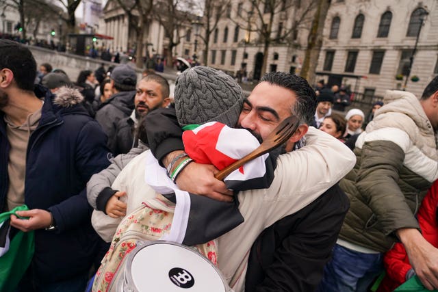 People hugging among Syrian flags