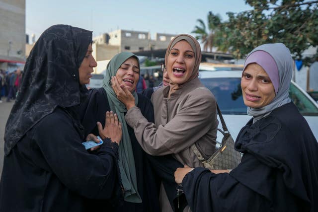 Palestinian women mourn over victims following an Israeli bombardment, at the Al-Aqsa Martyrs hospital in Deir al-Balah, Gaza Strip