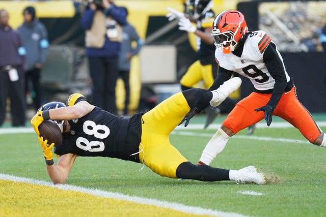 Pittsburgh Steelers tight end Pat Freiermuth scores in front of Cleveland Browns safety Grant Delpit