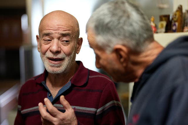 The freed man reacts as a man shows him a picture of a missing Lebanese prisoner