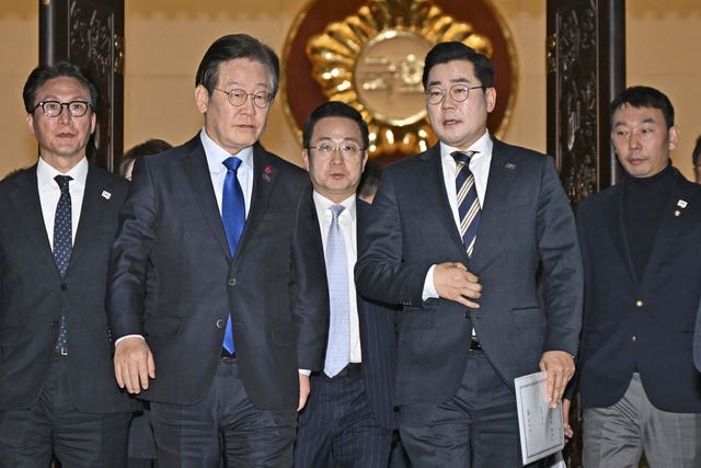 South Korea’s main opposition Democratic Party leader Lee Jae-myung, front left, and its floor leader Park Chan-dae, front right, leave a room at the National Assembly in Seoul after South Korea’s parliament voted to impeach President Yoon Suk Yeol