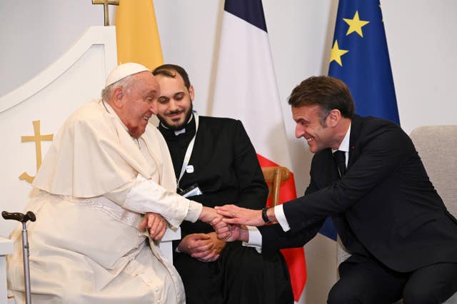 Pope Francis shakes hands with French President Emmanuel Macron